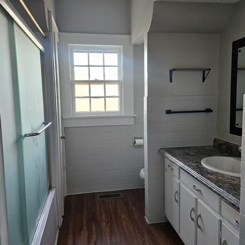 a bathroom with a granite countertop sink toilet and vanity