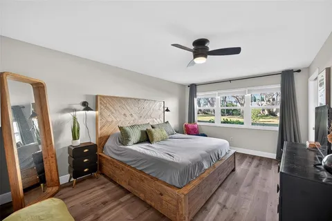 a bedroom with a bed a large window with flat screen tv and outdoor view