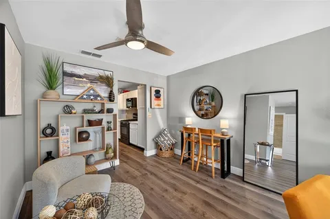 a living room with furniture a flat screen tv and a table