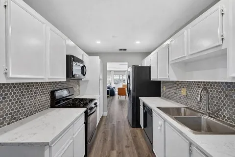 a kitchen with a sink a stove and cabinets