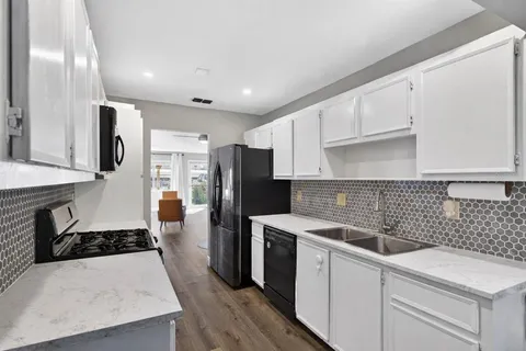 a kitchen with a sink a refrigerator and cabinets