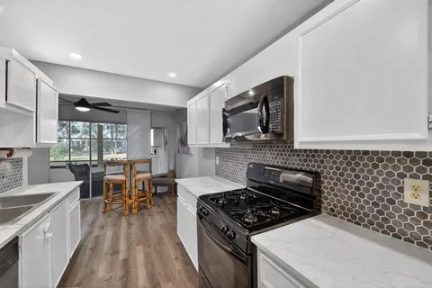 a kitchen with a stove a sink and wooden cabinets