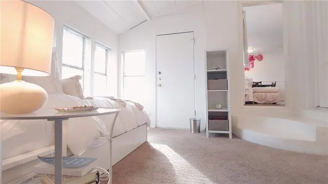 a spacious bedroom with a bed and a window