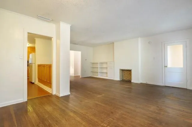 an empty room with wooden door and closet