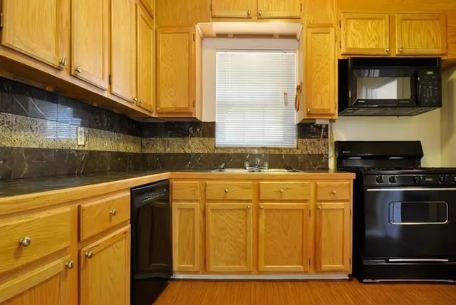 a kitchen with stainless steel appliances granite countertop a stove a sink and a microwave