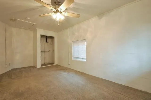 en empty room with windows and fan