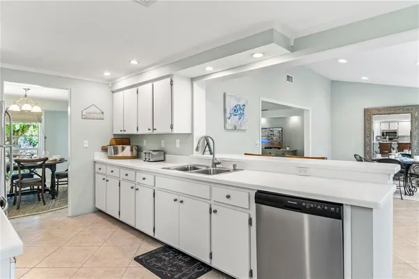 a kitchen with refrigerator a sink and white cabinets