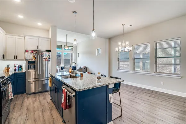 a kitchen with kitchen island granite countertop a sink appliances and wooden floor