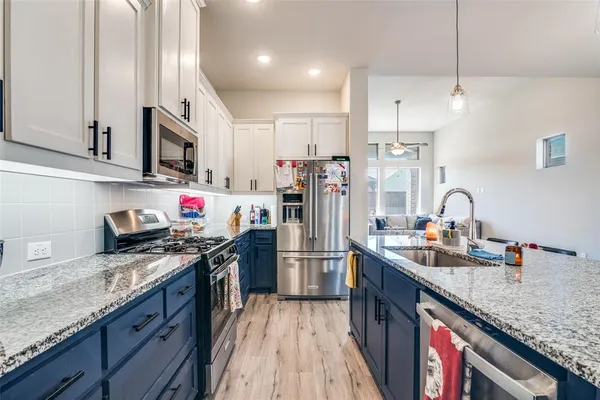 a kitchen with stainless steel appliances granite countertop a sink stove and refrigerator