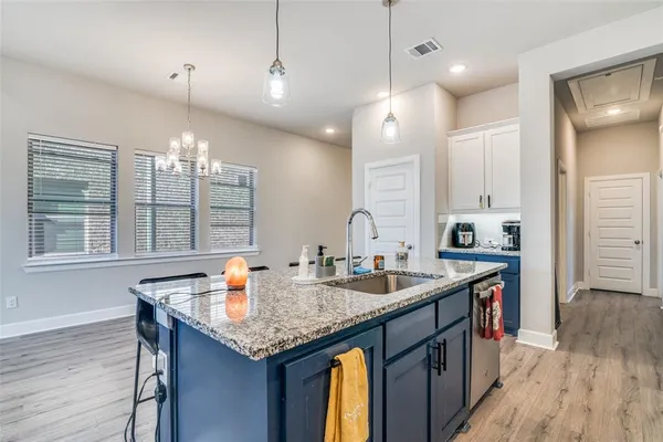 a kitchen with granite countertop kitchen island stainless steel appliances a sink and living room view