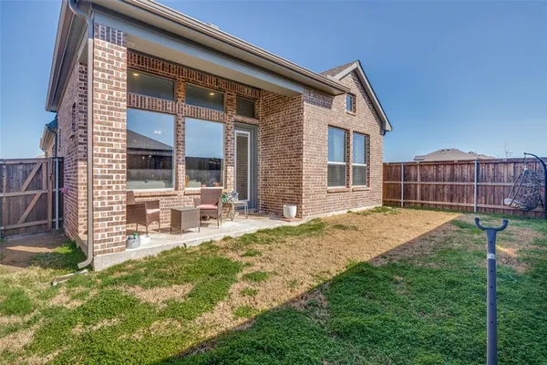 a view of house with backyard and sitting area