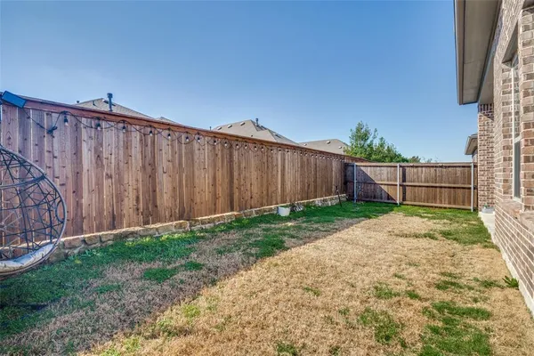 a view of backyard with wooden fence