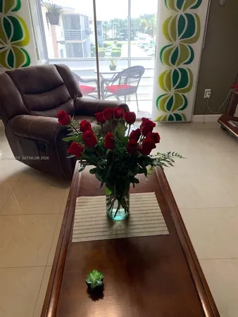 a vase of flowers sitting on a table with window