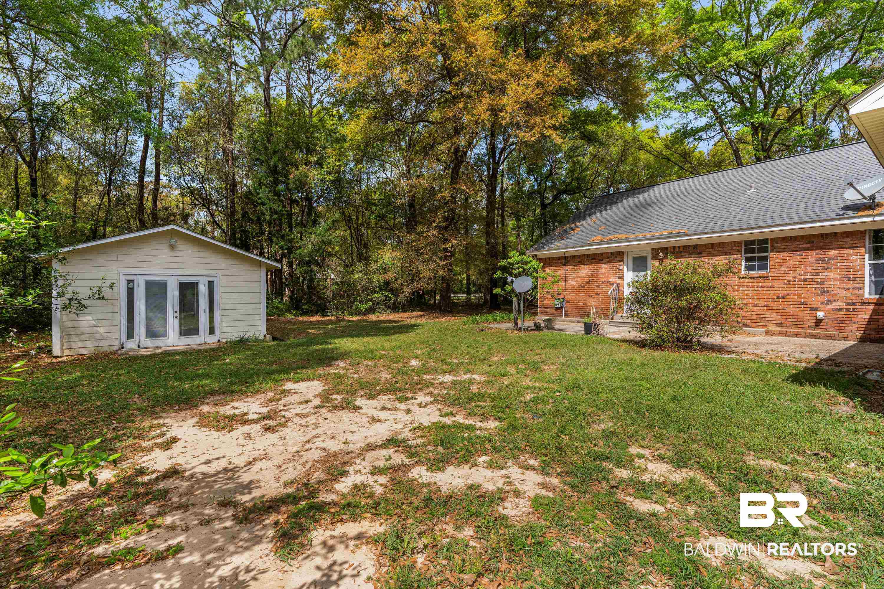10140 Lakeview Road Bay Minette, AL 36507 - Photo 23 of 35 View of grassy yard featuring an outdoor structure, french doors, a patio, and view of wooded area