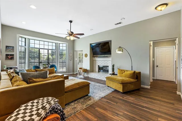 a living room with furniture a flat screen tv and a large window
