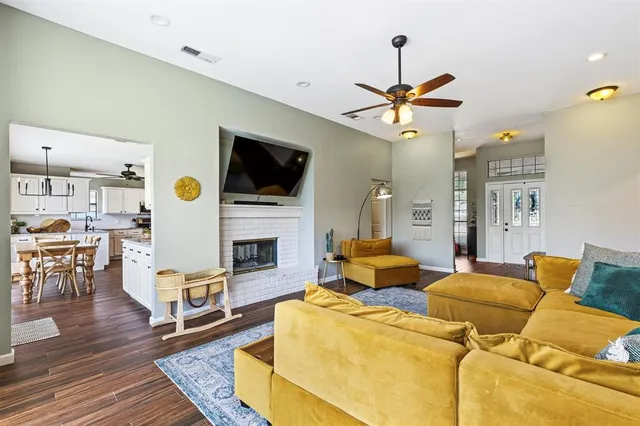 a living room with furniture a fireplace and a flat screen tv
