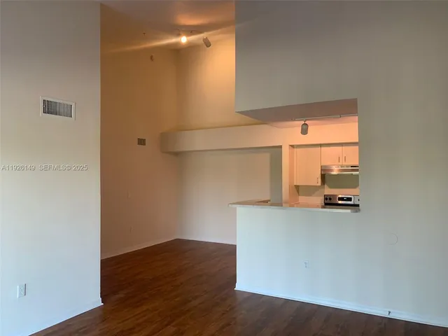 a view of a room with wooden floor and a window