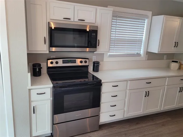 a kitchen with white cabinets stainless steel appliances and sink