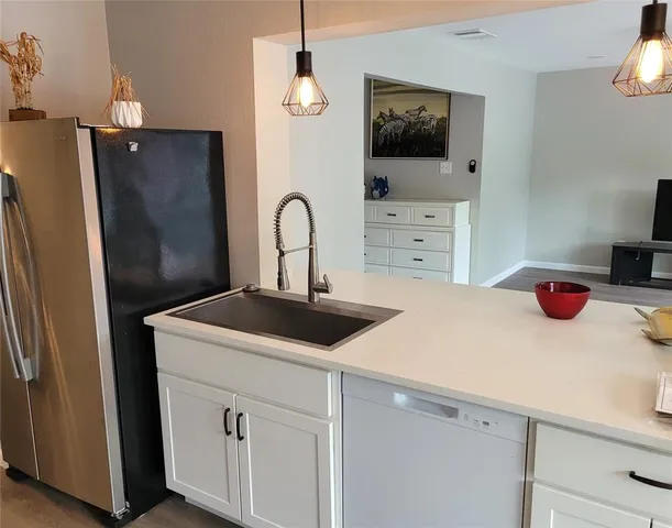 a kitchen with a sink a refrigerator and cabinets