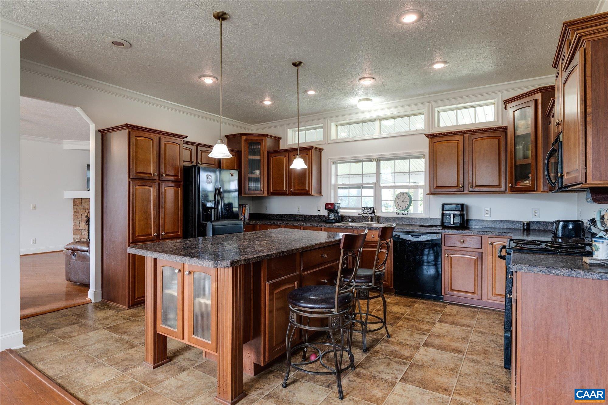 3225 Lynn Hollow Road North Tazewell, VA 24630 - Photo 31 of 62 a kitchen with kitchen island granite countertop wooden cabinets and a refrigerator
