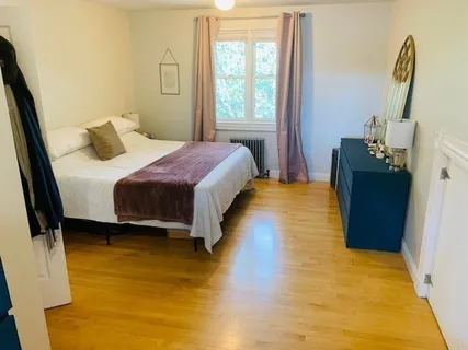 a bedroom with a bed and wooden floor