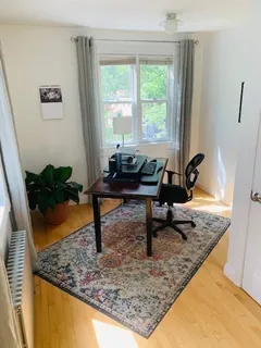 a view of a workspace room with wooden floor and a window