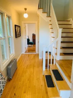 a view of an entryway with wooden floor and door
