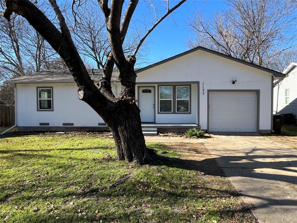 Ranch-style home featuring crawl space, driveway, an attached garage, and a front yard