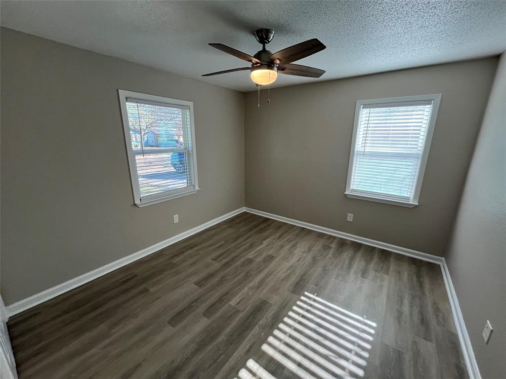 1125 Rancho Drive Mesquite, TX 75149 - Photo 12 of 23 Unfurnished room featuring dark wood finished floors, a textured ceiling, healthy amount of natural light, and ceiling fan