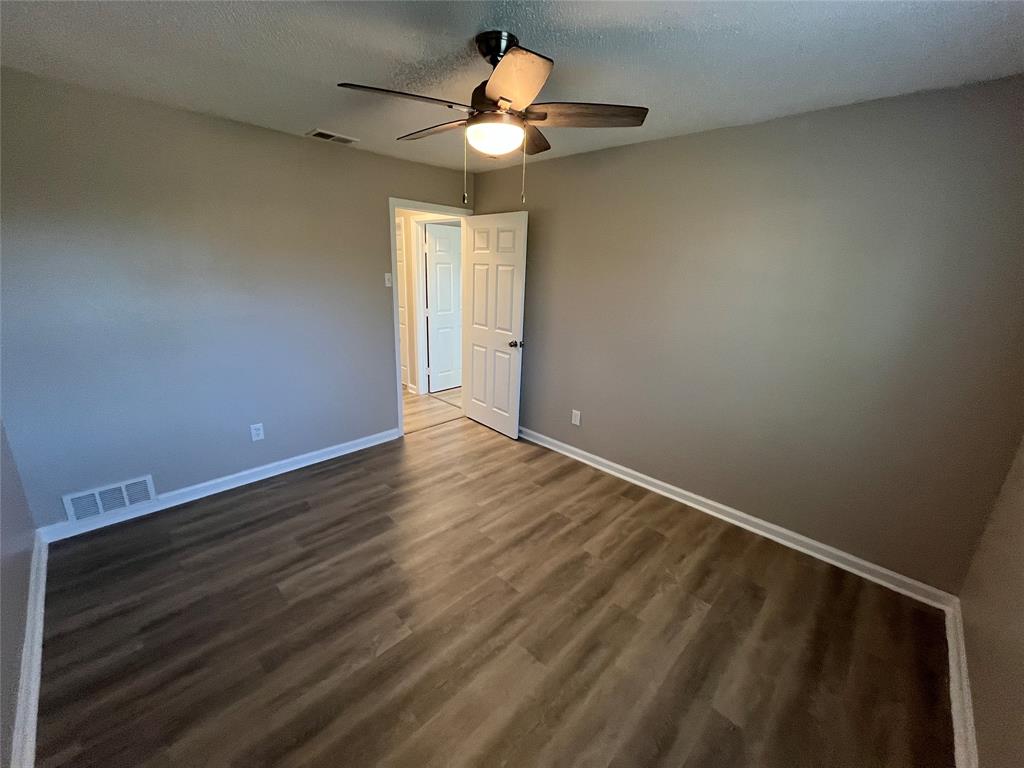 1125 Rancho Drive Mesquite, TX 75149 - Photo 18 of 23 Spare room featuring dark wood finished floors, a textured ceiling, and ceiling fan