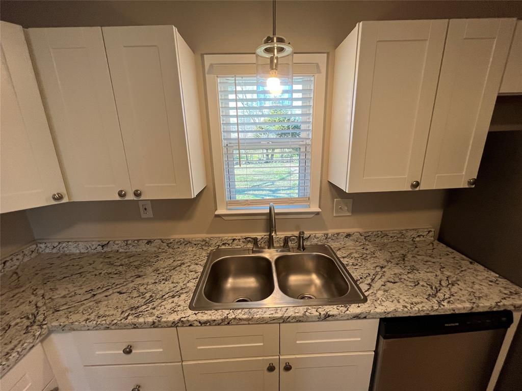 1125 Rancho Drive Mesquite, TX 75149 - Photo 9 of 23 Kitchen featuring white cabinets, stainless steel dishwasher, decorative light fixtures, and light stone countertops