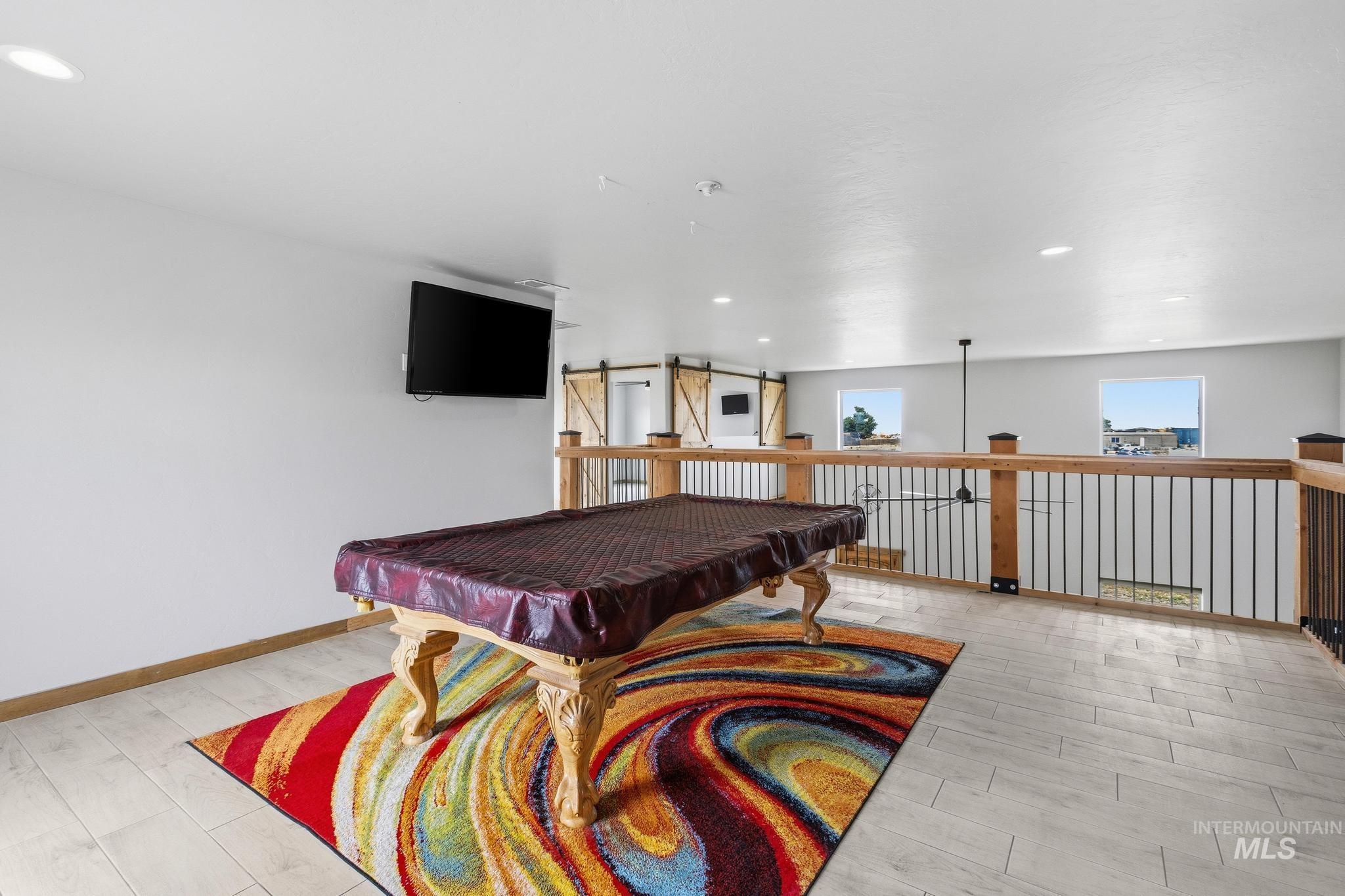 870 Desert Wind Road Boise, ID 83716 - Photo 27 of 50 Loft area with light wood-finish flooring and a wood railing featuring black metal spindles