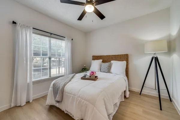 a bedroom with a bed and a large window