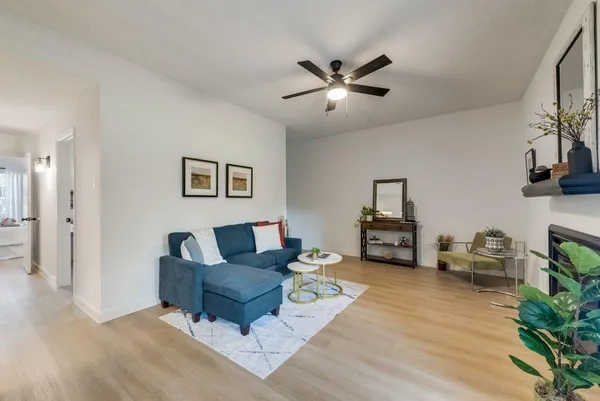 a living room with furniture and a wooden floor
