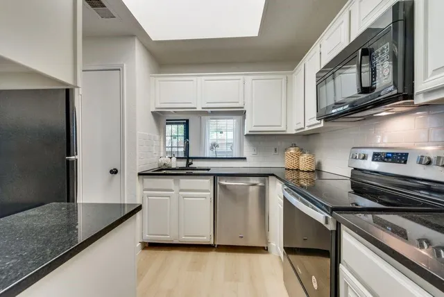 a kitchen with stainless steel appliances granite countertop a sink and stove top oven