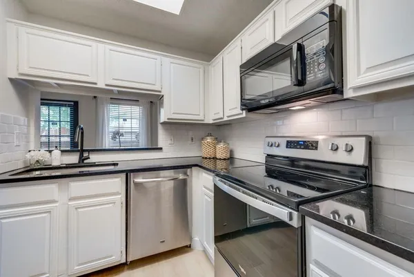 a kitchen with cabinets appliances and a sink