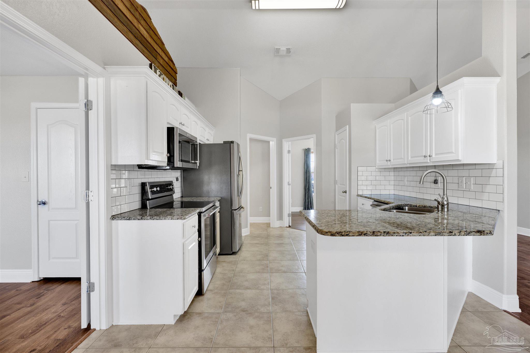 3351 North Simmons Road Jay, FL 32565 - Photo 13 of 36 a kitchen with stainless steel appliances granite countertop a sink a stove and a refrigerator