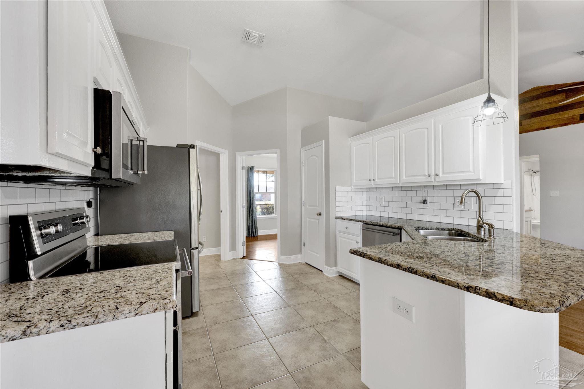 3351 North Simmons Road Jay, FL 32565 - Photo 14 of 36 a kitchen with stainless steel appliances granite countertop a sink refrigerator and cabinets