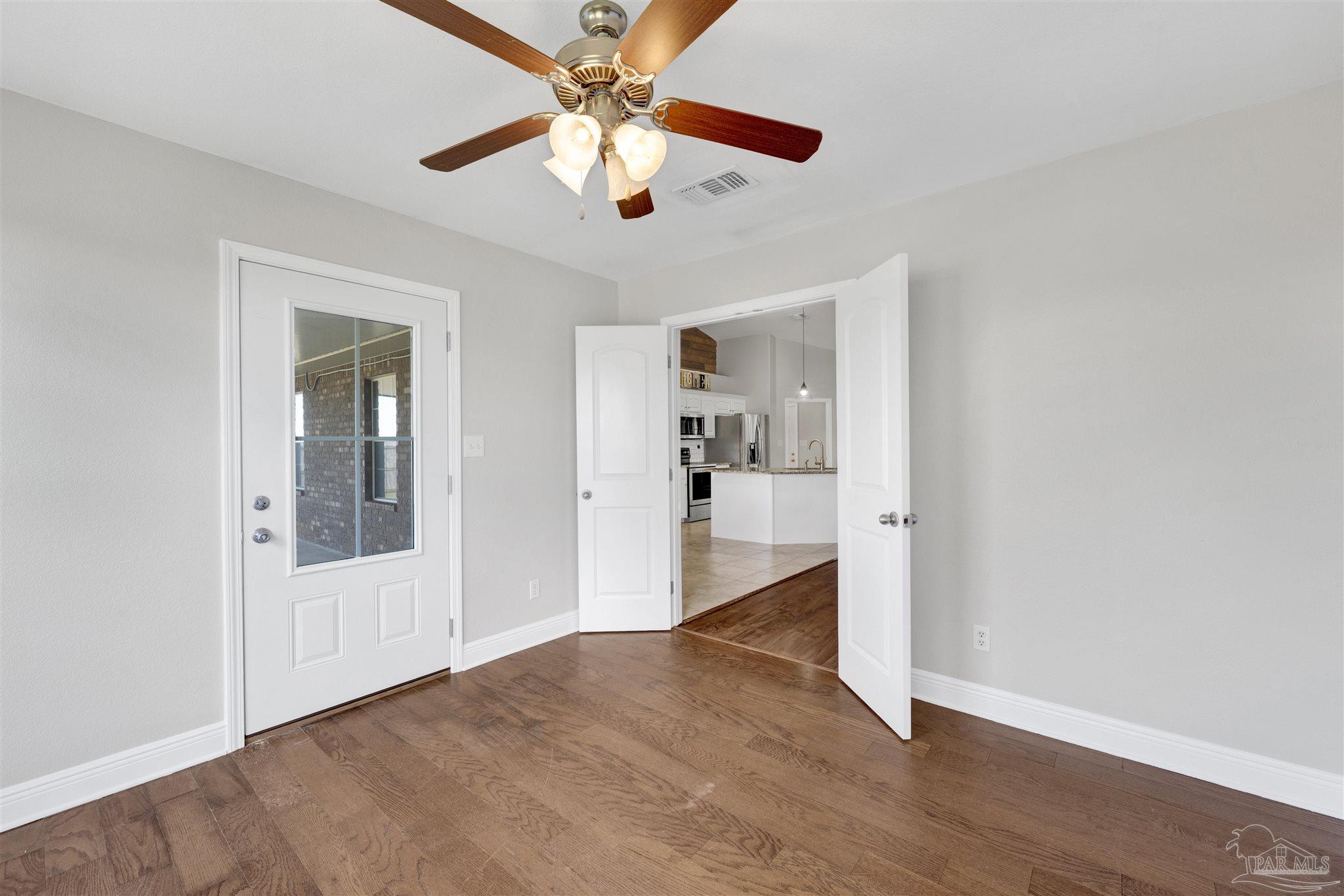 3351 North Simmons Road Jay, FL 32565 - Photo 16 of 36 wooden floor in an empty room with a chandelier fan