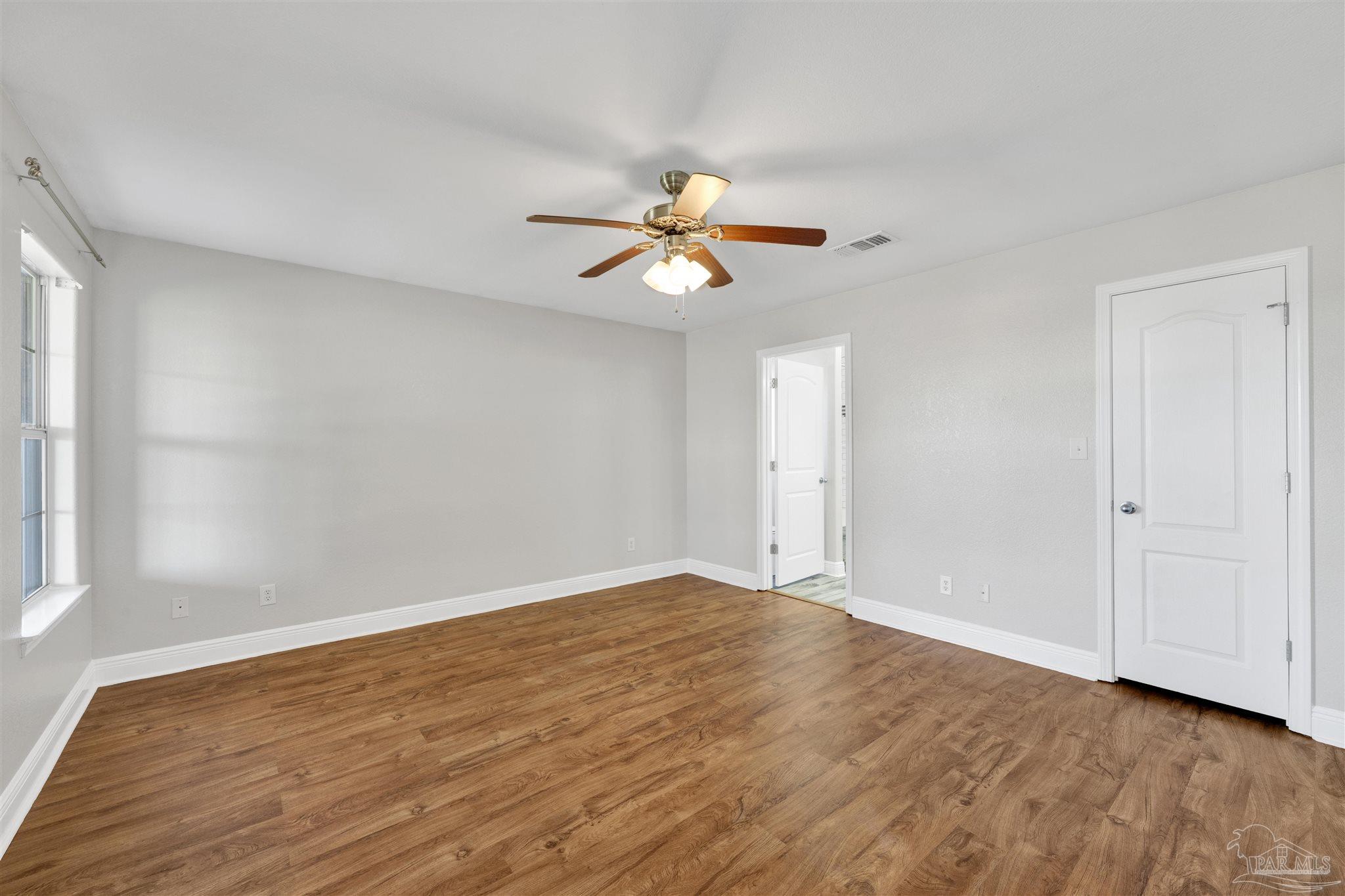 3351 North Simmons Road Jay, FL 32565 - Photo 18 of 36 a view of a room with a ceiling fan and wooden floor