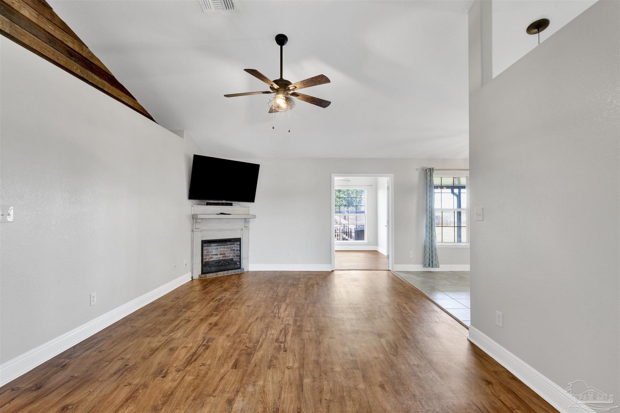 3351 North Simmons Road Jay, FL 32565 - Photo 4 of 36 a view of a livingroom with a fireplace a ceiling fan and wooden floor