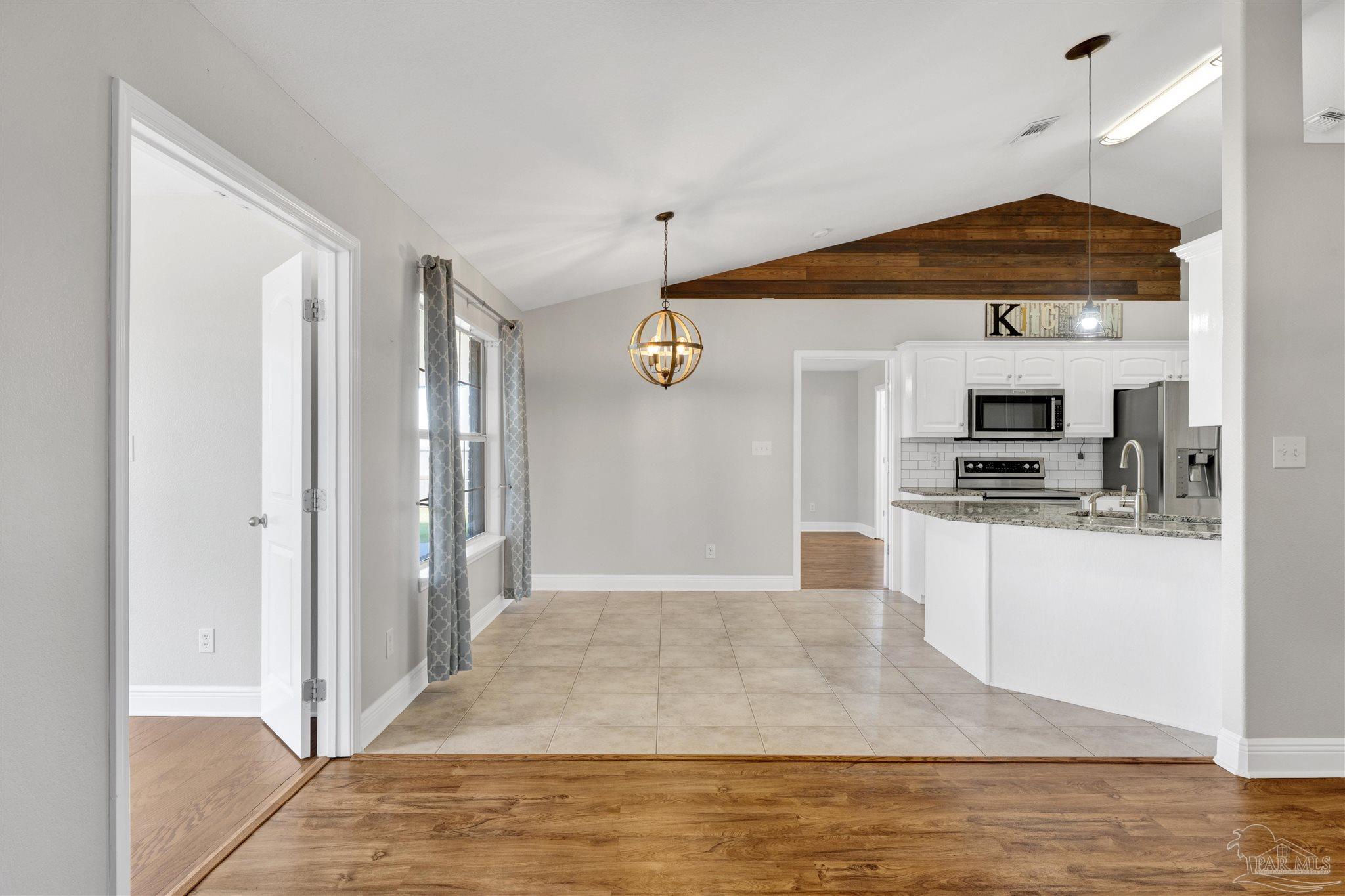 3351 North Simmons Road Jay, FL 32565 - Photo 9 of 36 a hallway with white cabinets and stainless steel appliances