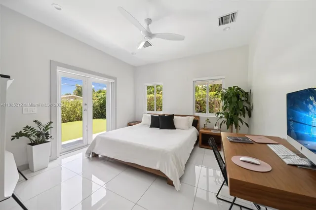 a living room with a bed furniture and a potted plant