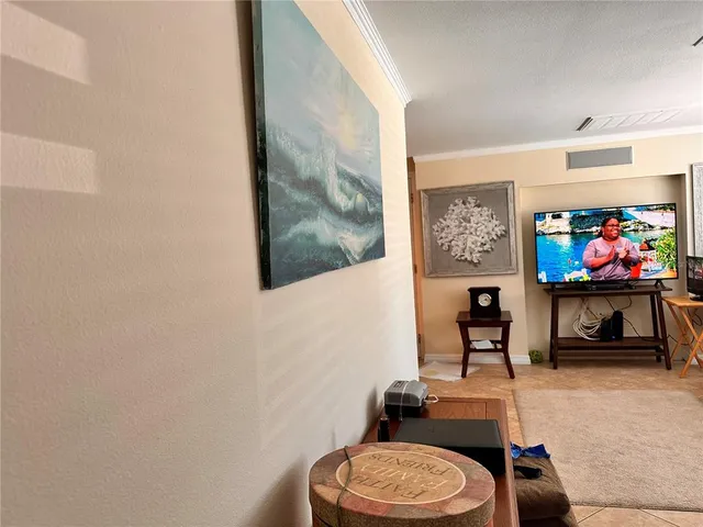 a living room with furniture a flat screen tv and a wall painting
