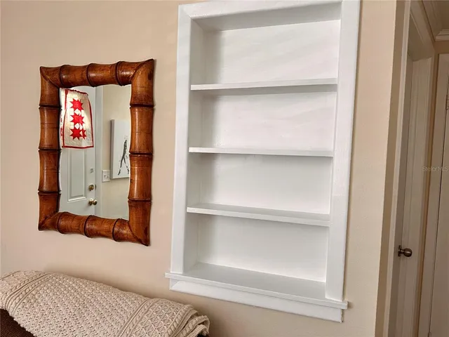 a utility room with a walk in closet and wooden floor