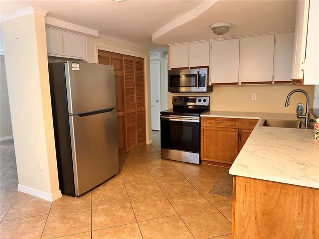 a kitchen with stainless steel appliances granite countertop a refrigerator a stove a sink a microwave and cabinets