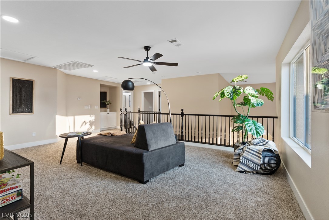 1662 Ravanusa Drive Henderson, NV 89052 - Photo 39 of 74 An open loft with a plush carpeted floor and an elegant black railing.
