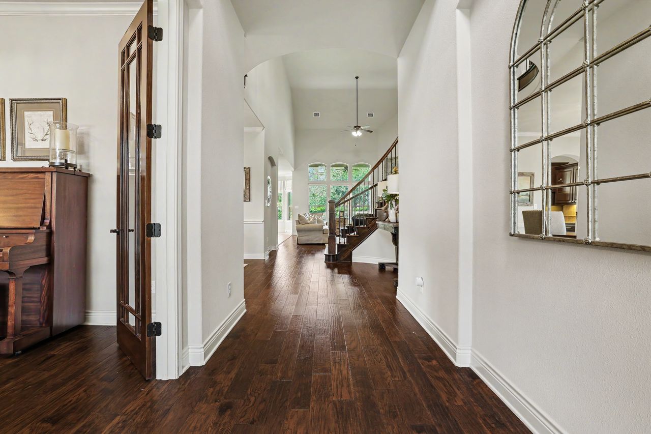 809 Prairie Dunes Drive Georgetown, TX 78628 - Photo 4 of 40 Rich hardwood floors welcome guests into this elegant entry hallway, flowing seamlessly towards a bright living space.