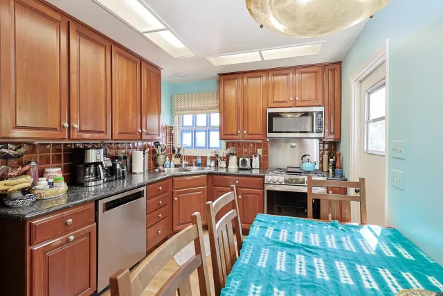 a kitchen with kitchen island granite countertop a stove top oven sink and cabinets