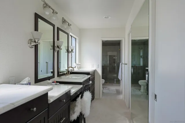 a spacious bathroom with a granite countertop sink and a mirror